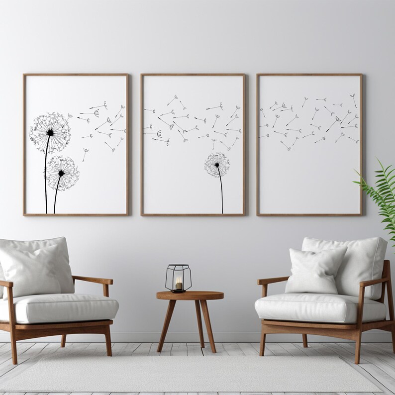 May include: A set of three rectangular wall art prints featuring black line drawings of dandelion seed heads on a white background. The artwork depicts dandelion flowers with seeds blowing in the wind across the three separate frames.