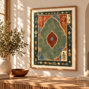 May include: A framed wall art print featuring a central sage green arch shape on a rust-orange background, surrounded by a dark teal border with small floral and geometric motifs in blue, cream, and orange, all enclosed in a light wood frame.