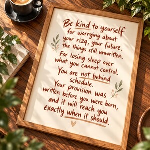 May include: A framed wall art print featuring brown text on a cream background that reads: Be kind to yourself for worrying about your rizq, your future, the things still unwritten. For losing sleep over what you cannot control. You are not behind schedule. Your provision was written before you were born, and it will reach you exactly when it should.