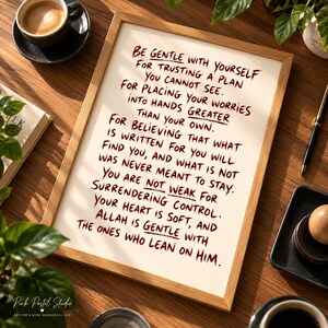 May include: A rectangular wooden frame containing a white print with dark red handwritten text that reads: Be gentle with yourself for trusting a plan you cannot see. For placing your worries into hands greater than your own. For believing that what is written for you will find you, and what is not was never meant to stay. You are not weak for surrendering control. Your heart is soft, and Allah is gentle with the ones who lean on him.
