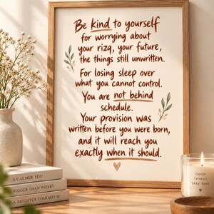 May include: A framed wall art print featuring brown handwritten text that reads: Be kind to yourself for worrying about your rizq, your future, the things still unwritten. For losing sleep over what you cannot control. You are not behind schedule.
