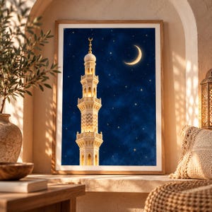May include: A framed vertical wall art print featuring a tall, illuminated minaret against a deep blue night sky filled with stars and a glowing crescent moon. The architectural structure is light-colored with intricate geometric patterns.