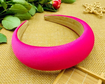 May include: A bright pink satin headband. The headband is thick and wide, and it is made of a soft, comfortable material.
