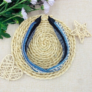 May include: A blue and white patterned headband with a black elastic band. The headband is on a woven straw mat.