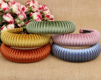 May include: Five velvet headbands in different colors: green, yellow, pink, orange, and blue. The headbands are all ribbed and have a wide, comfortable fit.