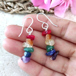 May include: Rainbow chakra earrings with silver hooks and a variety of gemstone beads, including red, orange, yellow, green, blue, and purple.