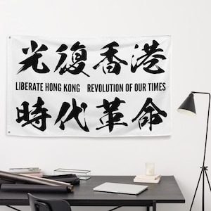 Può includere: Una bandiera bianca con caratteri cinesi neri e il testo "Liberate Hong Kong Rivoluzione dei nostri tempi".