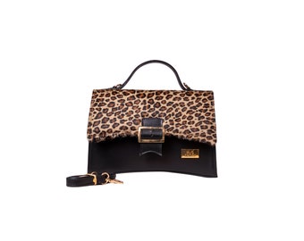 May include: A black leather handbag with a leopard print flap and a gold buckle. The bag has a detachable shoulder strap.