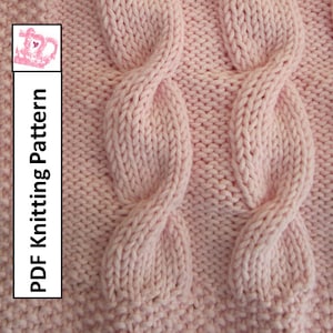 May include: A close-up of a pink knitted fabric with a cable knit pattern. The fabric is soft and textured, with a subtle sheen. The pattern is created by crossing the yarn over and under itself, creating a series of raised and indented stitches.
