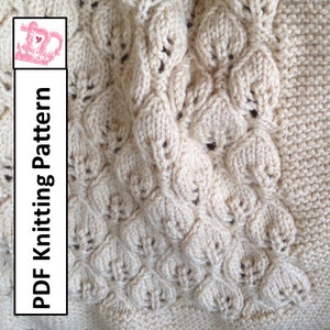 May include: A close-up of a knitted blanket featuring a delicate leaf pattern. The blanket is a creamy white colour and has a soft, textured surface. The text "PDF Knitting Pattern" is visible on the left side of the image.