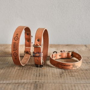 Puede incluir: Tres collares de perro de cuero marr&oacute;n con diferentes dise&ntilde;os grabados. El primer collar tiene la palabra "DJANGO" grabada. El segundo collar tiene un patr&oacute;n geom&eacute;trico colorido. El tercer collar tiene la palabra "Summer" grabada.