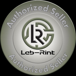 Pu&ograve; includere: Un distintivo circolare con una finitura metallica verde oliva e argento. Il centro mostra un logo nero stilizzato con le lettere LR all'interno di una cornice circolare. Sotto il logo si trova il testo Leb-Rint. Le parole Authorized Seller appaiono due volte.