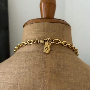 May include: A gold chain necklace with a gold tag that says "Judith Jack" hanging from it. The necklace is on a mannequin.