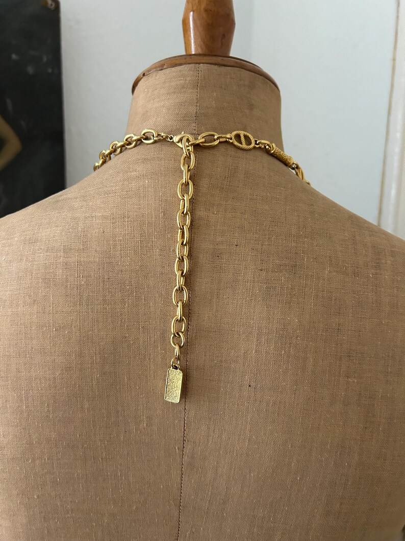 May include: Gold-toned chain necklace with a rectangular clasp. The chain is made of interlocking links.
