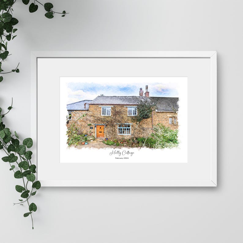 May include: A framed watercolor print of a stone cottage with a brown door and windows. The cottage is surrounded by greenery and the text "Holly Cottage" and "February 2024" are visible. The print is in a white frame.