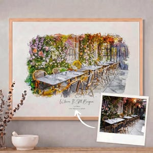 May include: A watercolour print of a restaurant scene, featuring tables and chairs set amidst vibrant flowers and foliage. The artwork is framed in a light wood frame. Text on the print reads "Where It All Began" and "Le Deux, 11th February 2020".