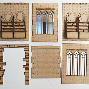 Op de afbeelding: Een set van zes lasergesneden houten stukken voor het bouwen van een model van een middeleeuws gebouw. De stukken omvatten een raam met de Latijnse tekst "Draco Dormiens Nunquam Titillandus", een boekenkast en een bakstenen muur.