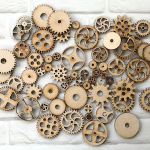 May include: A collection of various sized wooden gears and cogs, arranged on a white brick background. The gears have different designs, including circular, toothed, and spoked patterns. The natural wood color provides a warm contrast against the white.