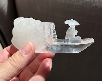 Detailed quartz carving of a warrior with his sword on a traditional fishing boat of Asia