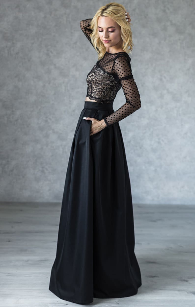 Stylish floor length black skirt with a wide pleats. Waist fit, has a sewn-in waistband about two inches wide. Made of polished cotton, with a slight sheen. Pockets in the side seams. Hidden zip fastening at the back.