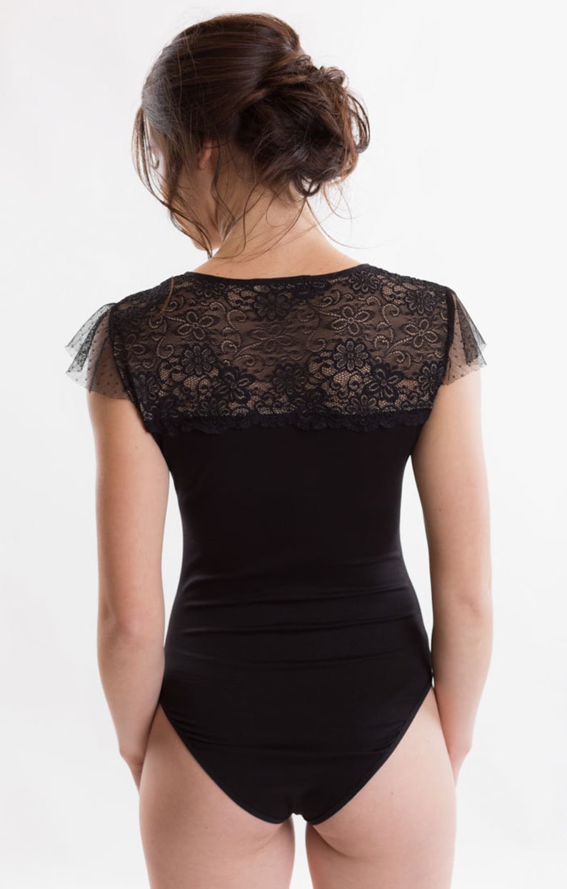 May include: Black bodysuit with a lace overlay and short sleeves.