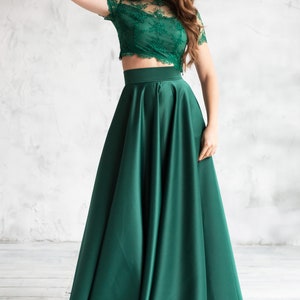 Long satin full sun emerald skirt. Fitted at the waist, a sewn-in wide belt (about 2" wide) closes with a hidden zipper. Made of dense satin with a beautiful matte sheen. Has pockets in the side seams. Without lining.