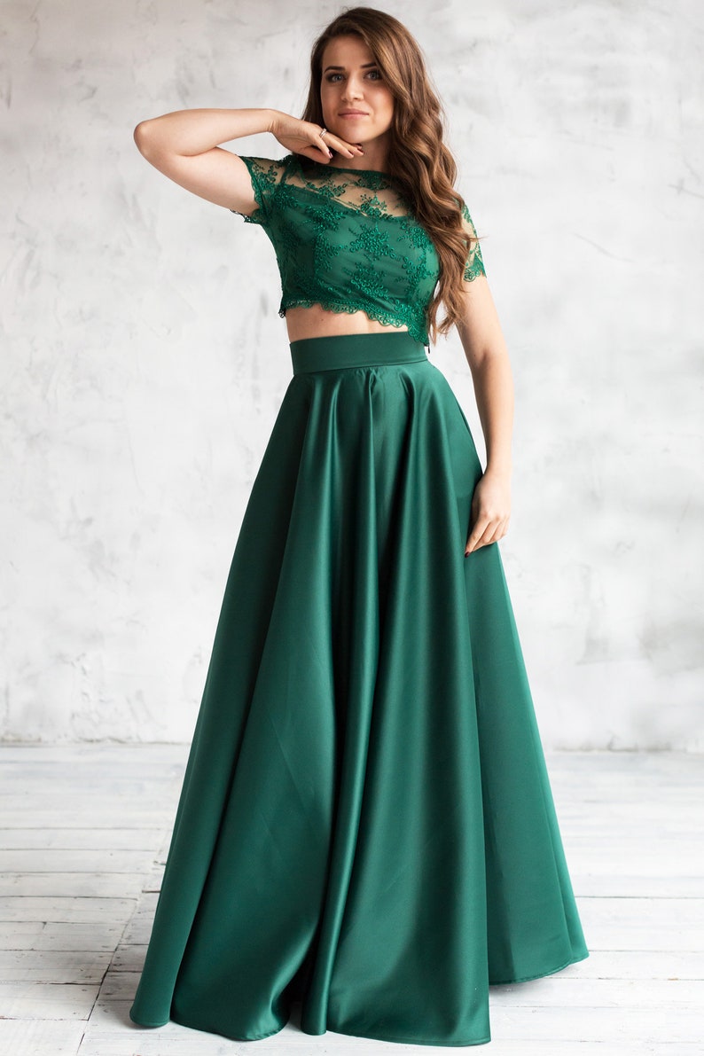 Long satin full sun emerald skirt. Fitted at the waist, a sewn-in wide belt (about 2" wide) closes with a hidden zipper. Made of dense satin with a beautiful matte sheen. Has pockets in the side seams. Without lining.