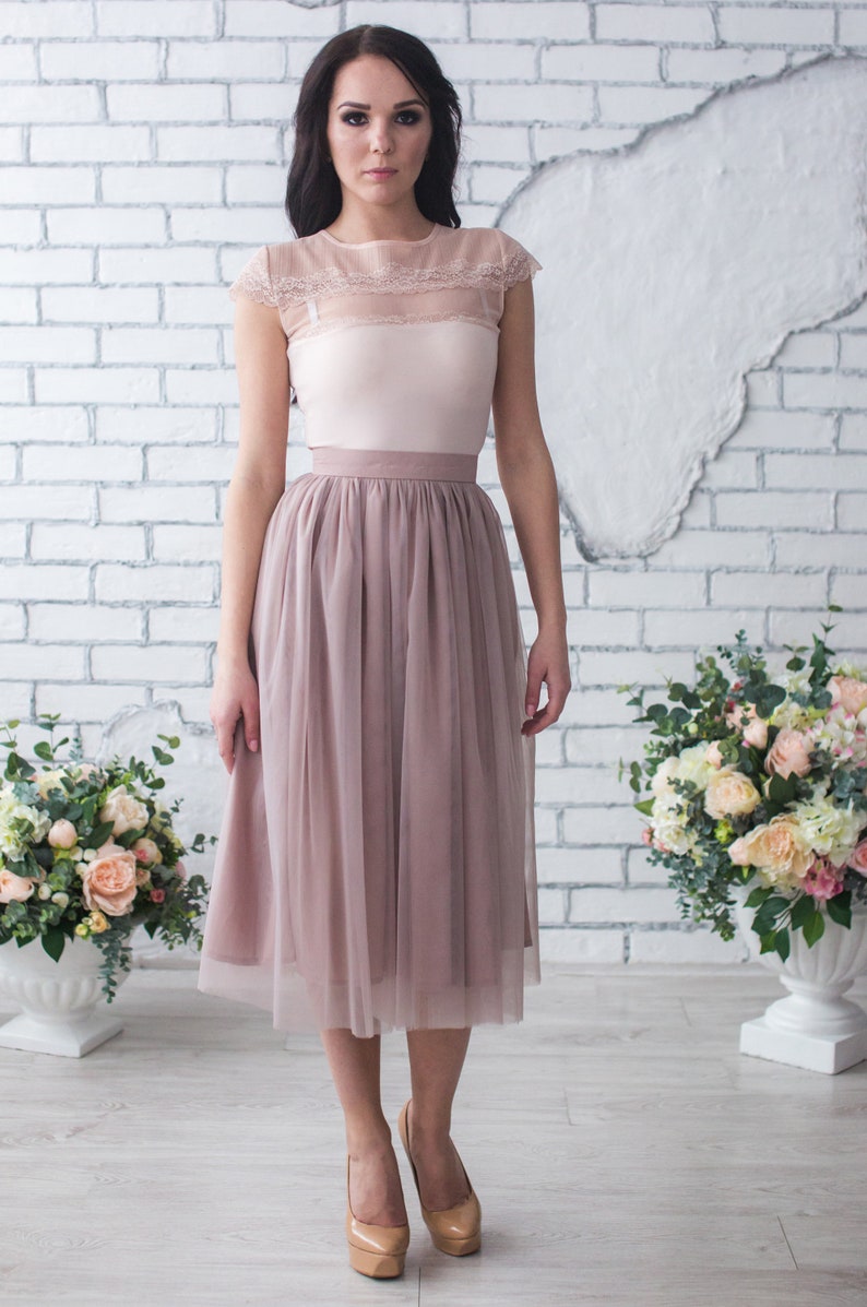 Fluffy tutu cocoa tulle skirt. Midi length, waist fit. Has a sewn-in waistband about two inches wide. Sewn from several layers of soft tulle, lined with chiffon. Very flowy and airy.