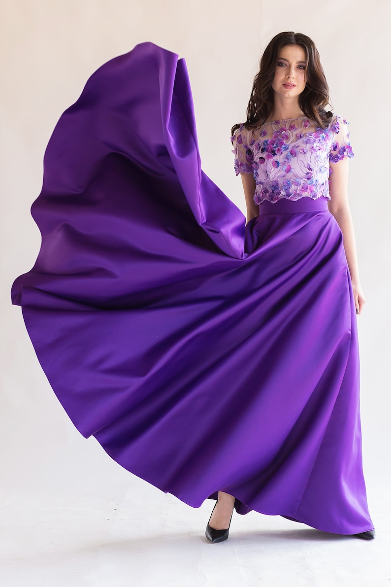 Long satin full sun purple skirt. Fitted at the waist, a sewn-in wide belt (about 2" wide) closes with a hidden zipper. Made of dense satin with a beautiful matte sheen. Has pockets in the side seams. Without lining.