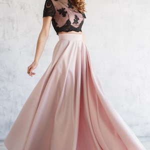 Long satin full sun blush skirt. Fitted at the waist, a sewn-in wide belt (about 2" wide) closes with a hidden zipper. Made of dense satin with a beautiful matte sheen. Has pockets in the side seams. Without lining.