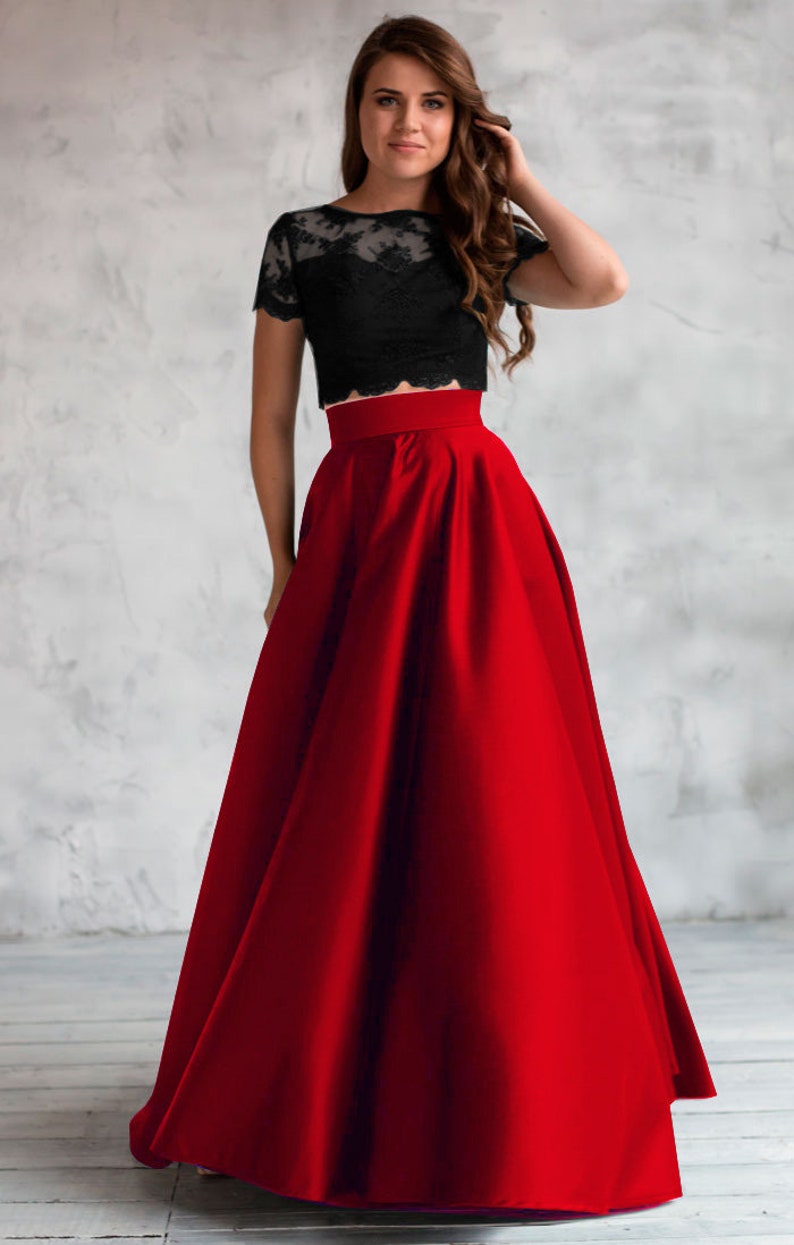 Long satin full sun red skirt. Fitted at the waist, a sewn-in wide belt (about 2" wide) closes with a hidden zipper. Made of dense satin with a beautiful matte sheen. Has pockets in the side seams. Without lining.