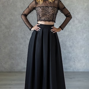 Stylish floor length black skirt with a wide pleats. Waist fit, has a sewn-in waistband about two inches wide. Made of polished cotton, with a slight sheen. Pockets in the side seams. Hidden zip fastening at the back.