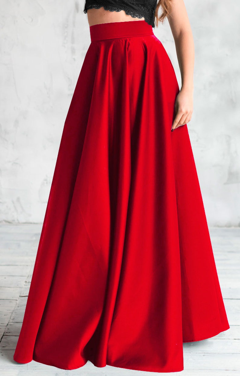 Long satin full sun red skirt. Fitted at the waist, a sewn-in wide belt (about 2" wide) closes with a hidden zipper. Made of dense satin with a beautiful matte sheen. Has pockets in the side seams. Without lining.