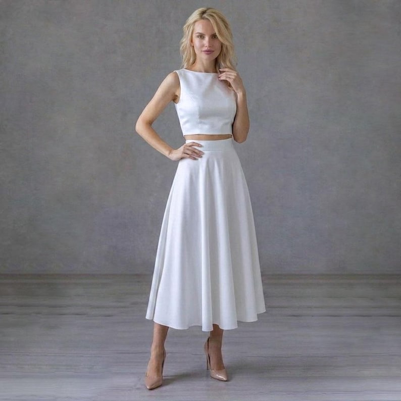 Elegante conjunto de dos piezas blanco: atuendo nupcial de falda midi y top corto sin mangas. imagen 1