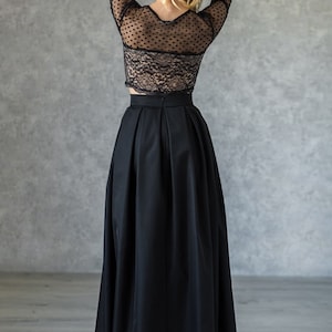 Stylish floor length black skirt with a wide pleats. Waist fit, has a sewn-in waistband about two inches wide. Made of polished cotton, with a slight sheen. Pockets in the side seams. Hidden zip fastening at the back.