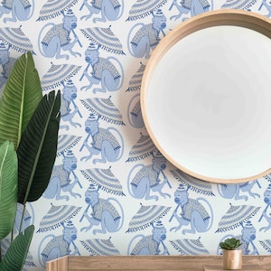 May include: White wallpaper with a repeating pattern of blue monkeys holding blue and white umbrellas. The monkeys are wearing blue and white patterned jackets. A wooden mirror with a white round mirror is in the background.