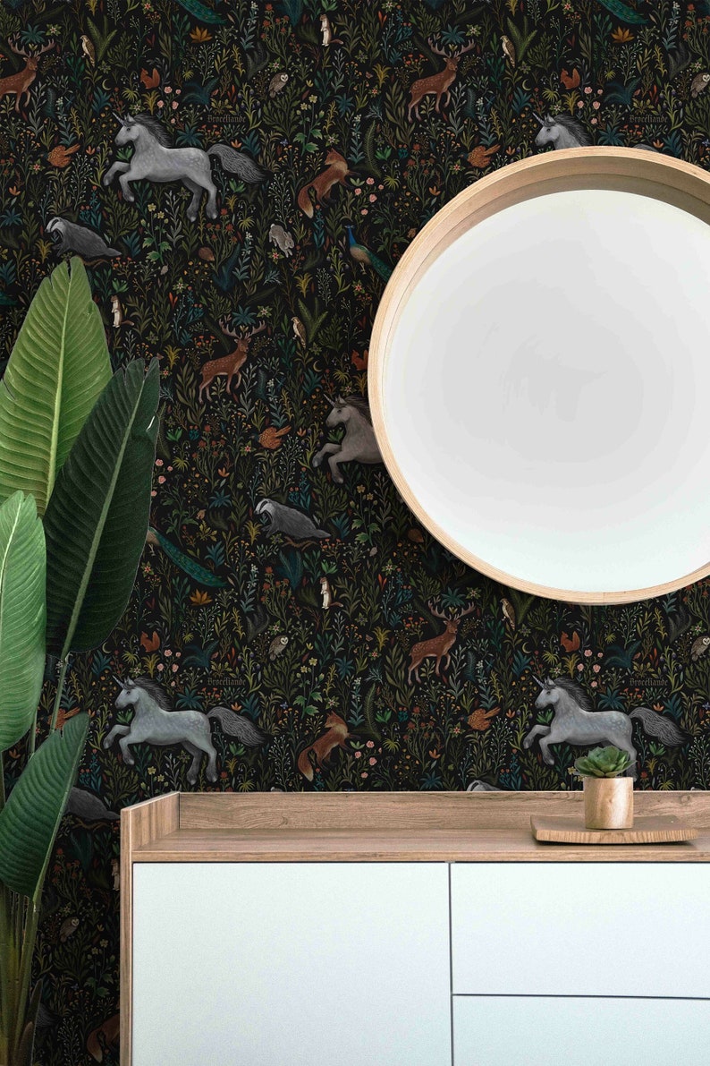 Puede incluir: Un papel tapiz en blanco y negro con una escena de bosque de ensue&ntilde;o con unicornios, ciervos, zorros y otras criaturas del bosque. El papel tapiz se muestra en una pared detr&aacute;s de una c&oacute;moda blanca con dos cajones.