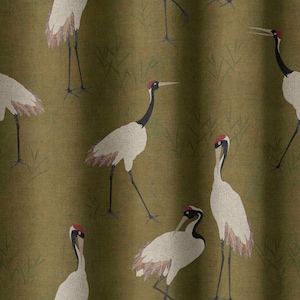 May include: Olive green fabric featuring a repeating pattern of Japanese cranes. The cranes have white bodies, black necks, and red crowns. The design includes stylized grass elements, creating a serene, nature-inspired aesthetic.