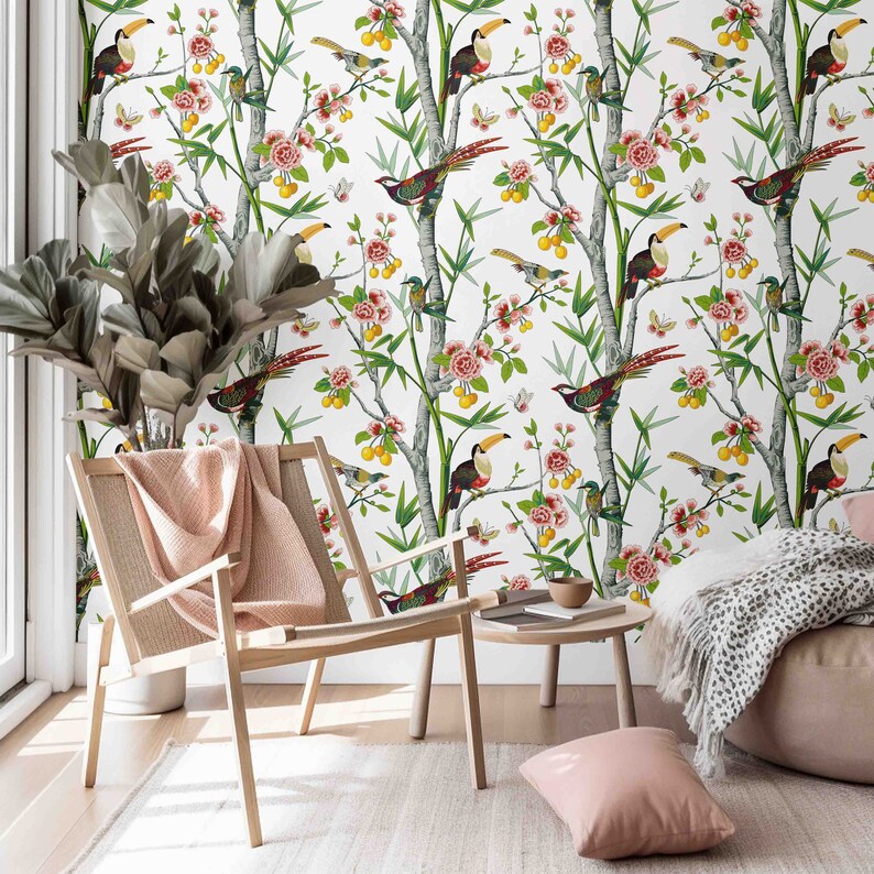 May include: A white wallpaper with a tropical theme featuring toucans, birds, and flowers. The wallpaper is displayed in a room with a wooden chair and a throw pillow.