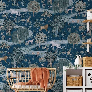 May include: Dark teal wallpaper with a whimsical forest scene featuring lions, unicorns, and deer. The design includes trees, winding paths, and various birds. A wicker baby crib with an orange blanket is in the foreground, with shelves and storage baskets.