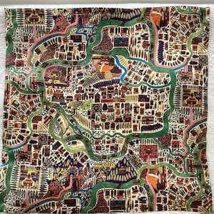 May include: A square fabric cushion cover featuring a detailed, colorful map-like illustration of a landscape with winding green rivers, clusters of small buildings, stylized trees, and mountain ranges in shades of orange, purple, and yellow.