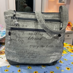 Bonitas frases sinceras en gris sobre un bolso de tela suave gris tipo bandolera o bandolera ajustable con cremallera de seguridad. 100 % hecho a mano.