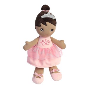 May include: A brown-skinned plush doll wearing a pink tulle ballerina dress with a crown and heart embroidery. The doll has brown hair and a silver crown on her head.