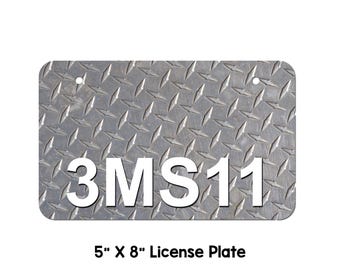 Puede incluir: Una placa de matrícula de metal de 12,7 cm por 20,3 cm con un patrón de placa de diamante y el texto "3MS11" en blanco.