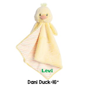 以下が含まれることがあります： 柔らかい黄色のぬいぐるみのアヒルの玩具と、お揃いの毛布。アヒルは薄い黄色の体、桃色のくちばし、そして「Levi」と書かれた緑色のネームタグを持っています。毛布はストライプ模様です。「Dani Duck-16」の文字が下にあります。