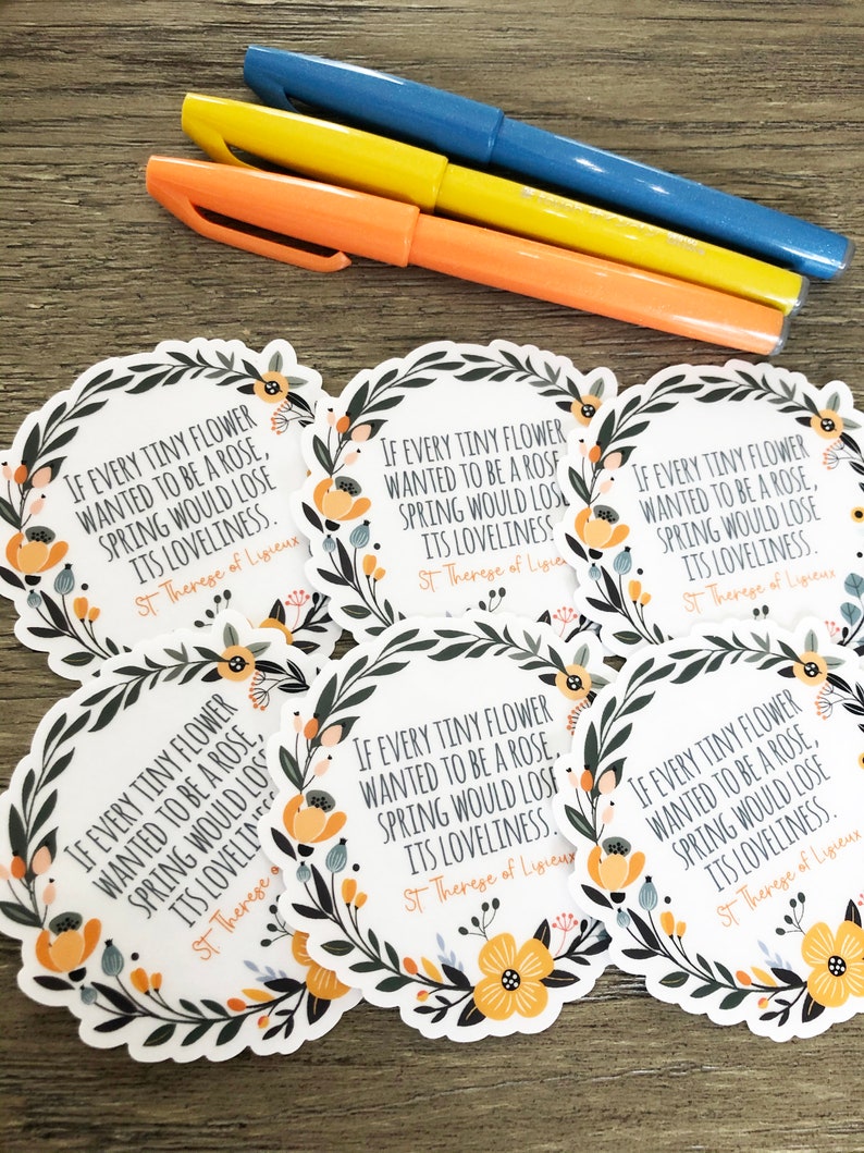 Op de afbeelding: Zes ronde stickers met een bloemige rand en een citaat van Heilige Theresia van Lisieux: "Als elke kleine bloem een roos wilde zijn, zou de lente zijn schoonheid verliezen."
