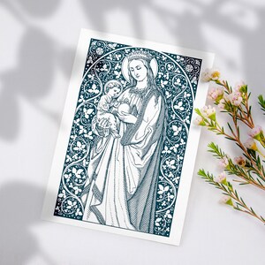 May include: A black and white illustration of the Virgin Mary holding a baby Jesus. The image is surrounded by a decorative border of leaves and flowers.