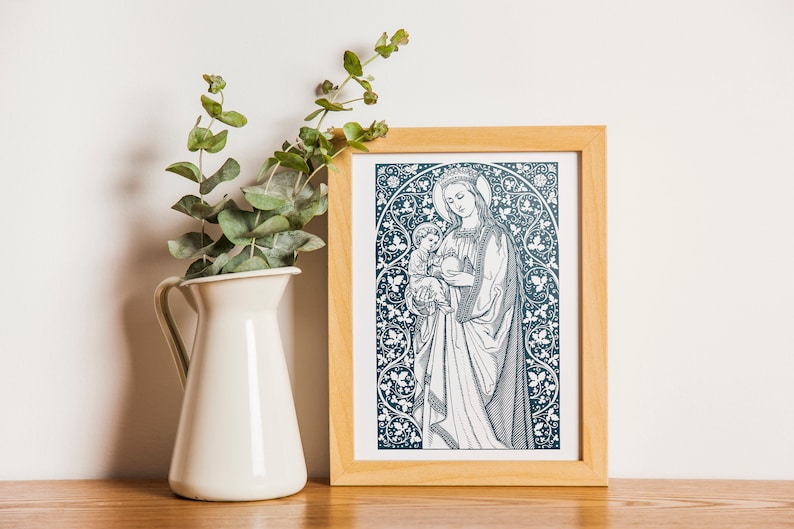 May include: A framed print of a blue and white illustration of the Virgin Mary holding a baby Jesus. The illustration is surrounded by a decorative floral border.