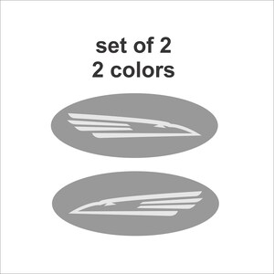 May include: Set of two gray oval decals with a white stylized bird wing design. The text "set of 2 2 colors" is above the decals.