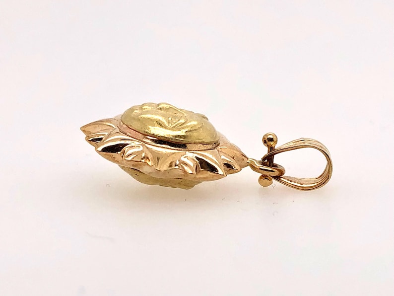 May include: A gold sun pendant with a detailed face design. The pendant has a loop for attaching to a chain.